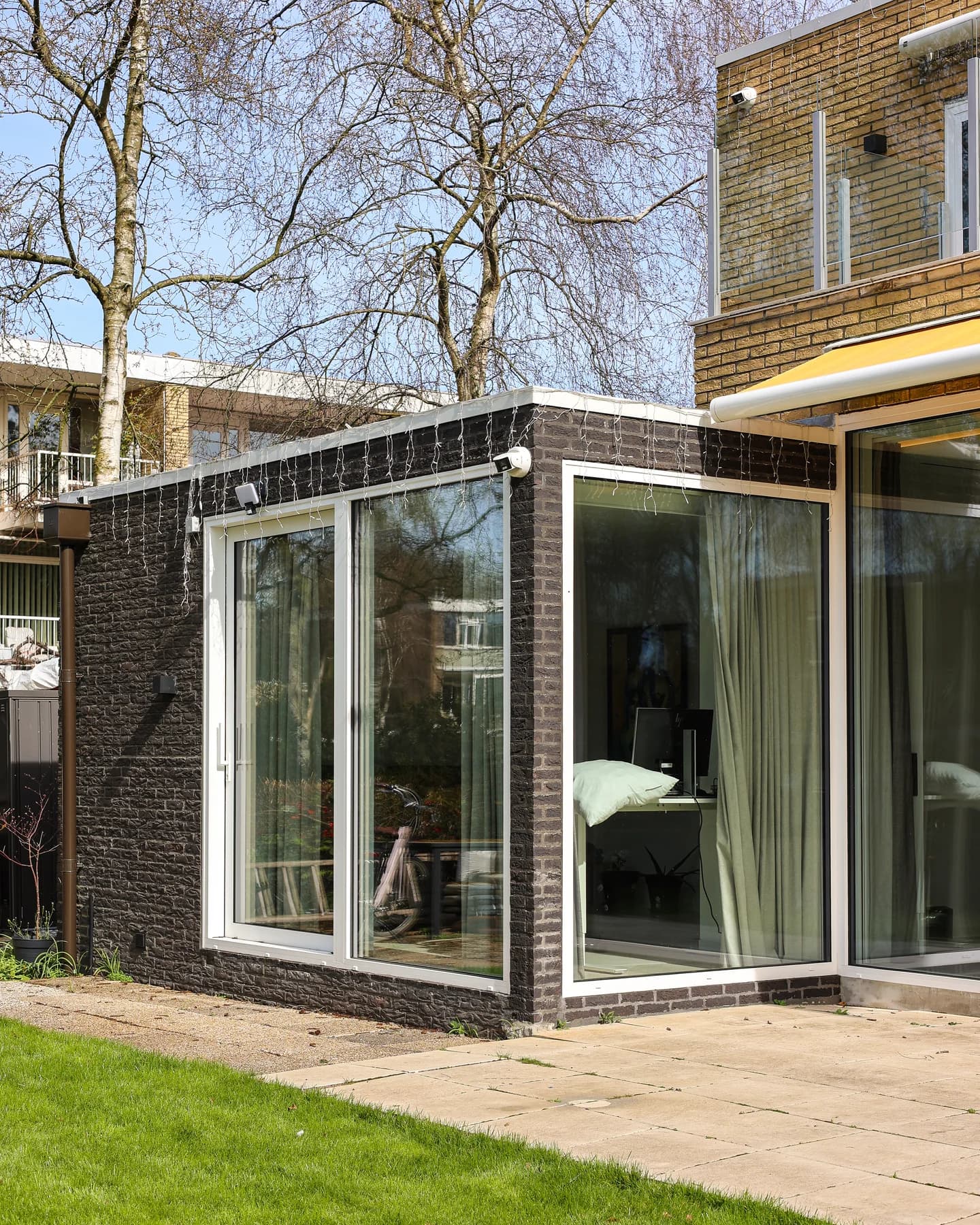 Glazen hoek van een aanbouw met lichte kozijnen