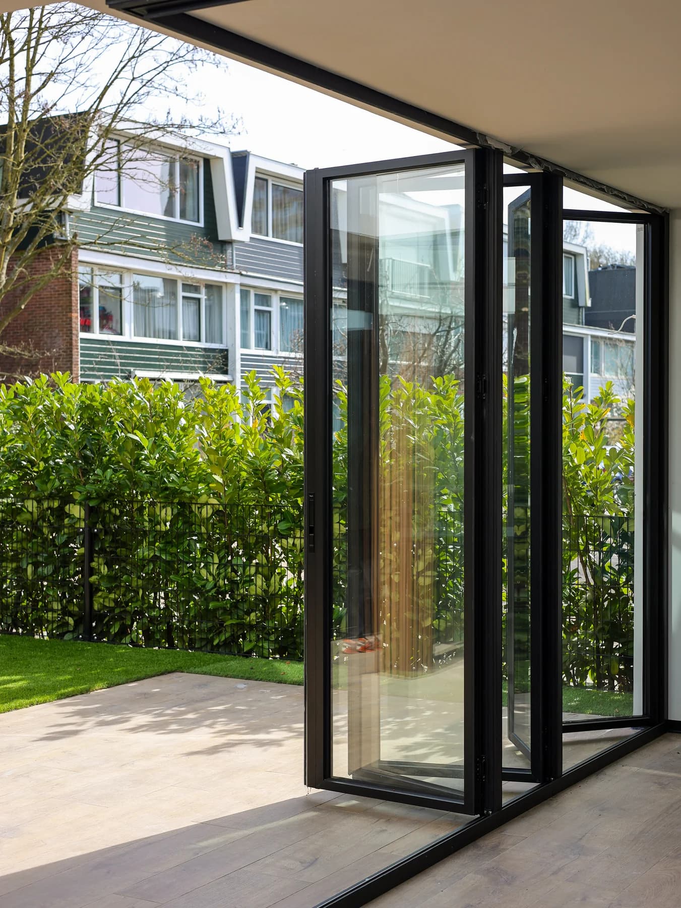 Geopende harmonicadeuren verbinden de woonkamer met de tuin